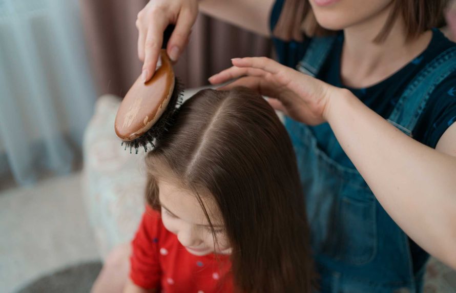 Une enfant se faisant coiffer